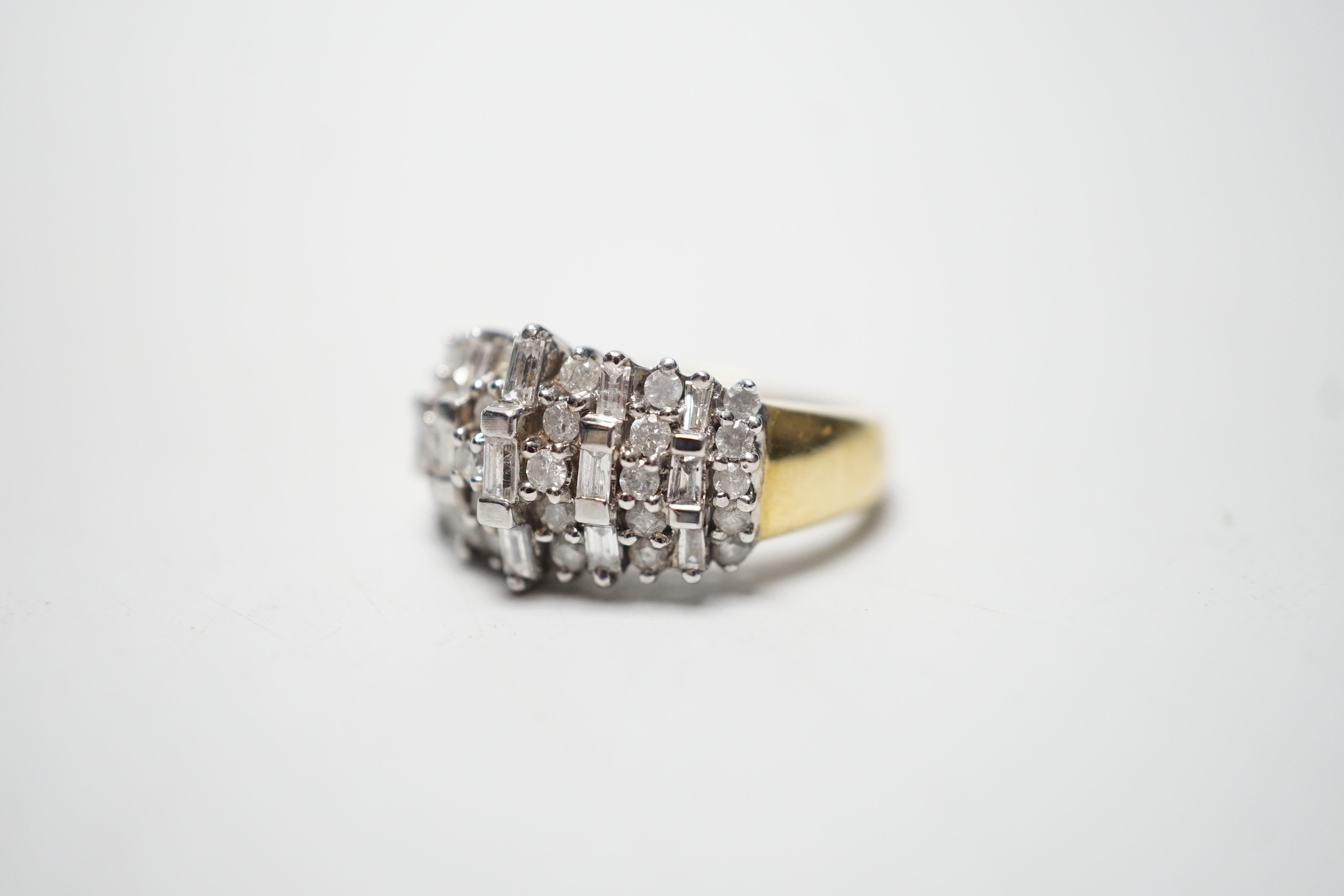 A modern yellow metal, round and baguette cut diamond set half hoop cluster ring, size L/M, gross weight 5.6 grams.